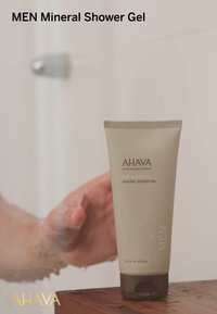 AHAVA MEN Mineral Shower Gel i en beige tube med bruna detaljer, 200 ml, har vattendroppar och tryckt text på framsidan.