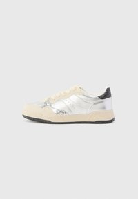 Hopea ja kerma sneaker, jossa on teksturoitu pinta, kimaltavat yksityiskohdat, sileä nahka ja musta kantapää. Kumipohja.