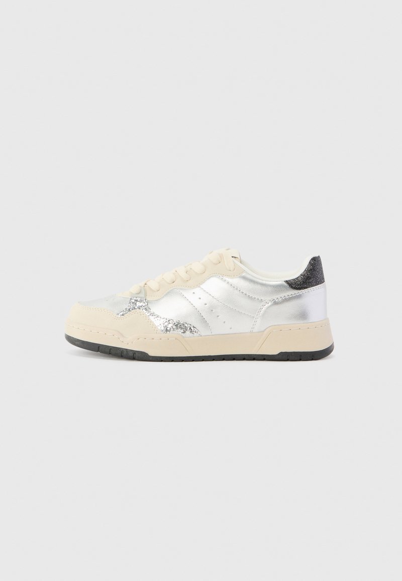 Hopea ja kerma sneaker, jossa on teksturoitu pinta, kimaltavat yksityiskohdat, sileä nahka ja musta kantapää. Kumipohja.