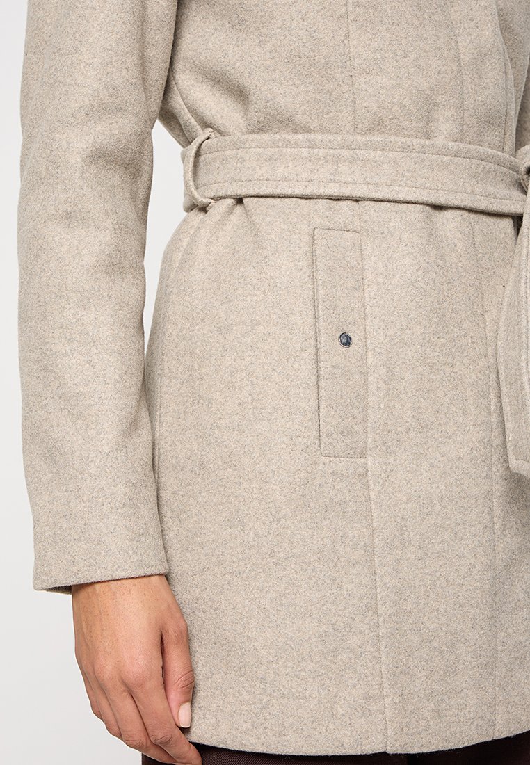 Beige wollen jas met een ceintuur in de taille, lange mouwen en een enkele borstzak met een knoop. Geweven, warme stof met een gestructureerd ontwerp.