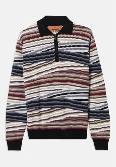 Adīta džemperis ar rāvējslēdzēju, kas rotāts ar košā krāsā zigzag rakstu sarkanā, zilā, melnā un bēšā nokrāsā; melns apkakle un ribota apakša.