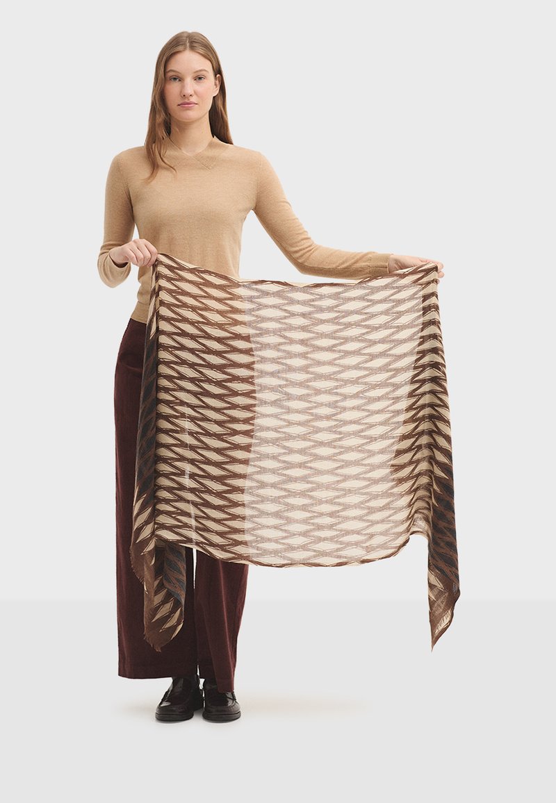 Écharpe à motifs marron et crème maintenue, présentant un design géométrique avec des bords frangés. Texture légère, forme rectangulaire.