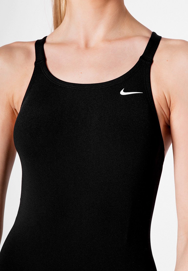 Maillot de bain de sport noir avec des fines bretelles. Fabriqué en tissu lisse et extensible. Présente un petit logo Nike blanc sur la zone de la poitrine.