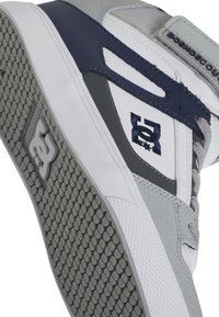 Αθλητικά παπούτσια ψηλά με γκρι, ναυτικό και λευκό χρωματικό σχέδιο. Επιφάνεια από υφασμάτινο καουτσούκ, επενδεδυμένος λαιμός και κεντημένη λεπτομέρεια λογότυπου.