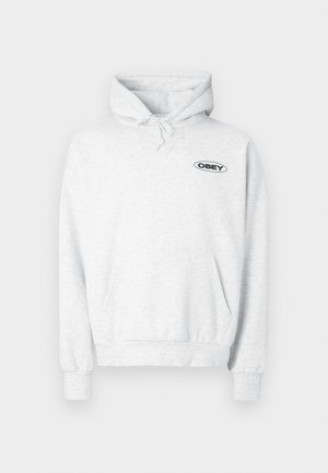 Lysegrå hettejakke laget av mykt stoff, med kengurulomme, snor i hetten og en svart "OBEY"-logo på brystet.