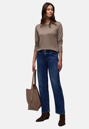 Beige långärmad topp kombinerad med blå jeans med raka ben, bruna ankelstövlar och en taupe-färgad toteväska. Slät tyg, klassisk passform och rena linjer.