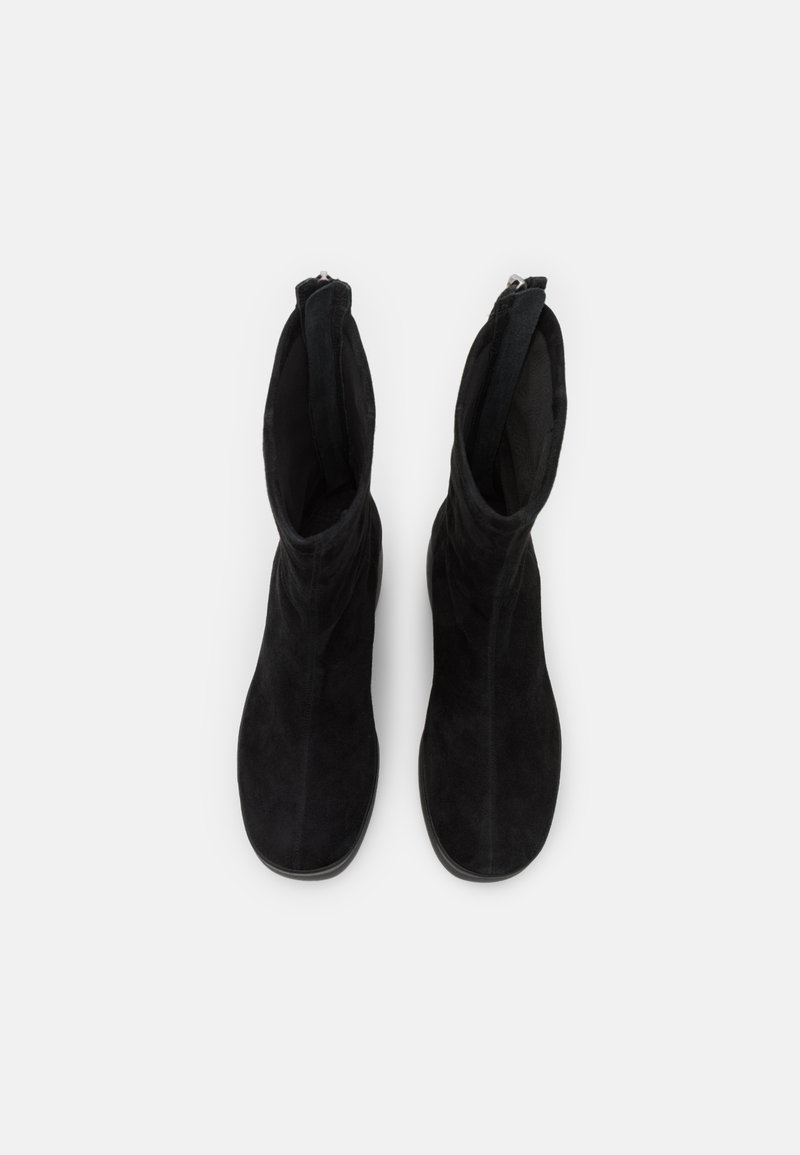 Czarne zamszowe botki za kostkę o gładkiej fakturze, dopasowanym kroju i detalach w postaci suwaka u góry. Podeszwa jest płaska i zaokrąglona na palcach.