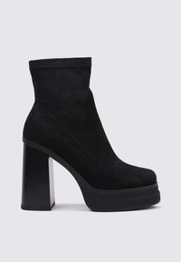 Botín de ante negro con plataforma y tacón cuadrado grueso. Presenta una textura suave y un diseño elegante. Sin adornos visibles.