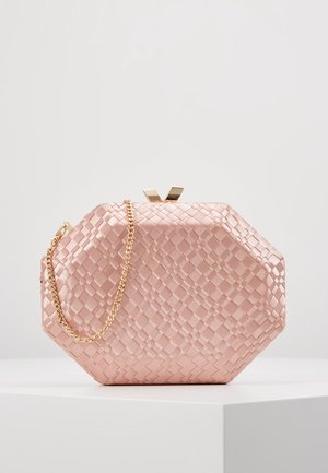 Clutch octagonal de satén rosa con un patrón tejido y correa de cadena dorada, exhibido sobre una superficie blanca.