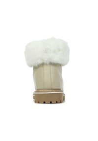 Bottine en cuir beige avec bordure en fausse fourrure blanche, surface texturée et semelle en caoutchouc robuste. Design comprenant un talon épais et des coutures contrastées.