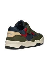 Sneaker verde e blu navy con tomaia testurizzata, dettagli rossi e strap in velcro. Presenta una suola bianca e battistrada in gomma.