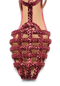 Sandalia trenzada roja con un diseño de punta abierta. Presenta correas tejidas en un patrón entrelazado y una plantilla suave color beige.