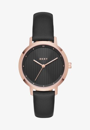 Montre à boîtier rond en or rose avec cadran texturé noir, aiguilles en or rose, points comme index des heures, bracelet en cuir noir et logo DKNY à 12 heures.