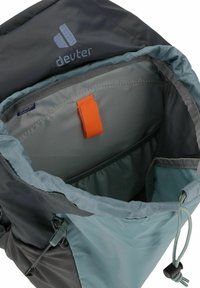 Deuter rugzak met een grijze buitenkant en licht teal voering. Bevat een oranje trekstrip en een verstelbaar koord, plus een binnenzak.