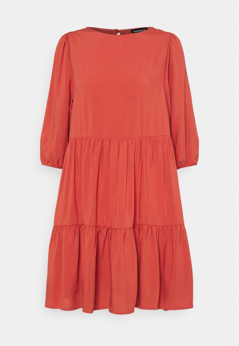 Ein knielanges, gestuftes Kleid in rostorange, mit rundem Ausschnitt, langen Ärmeln und einem weichen, glatten Stoff mit leichtem Glanz.