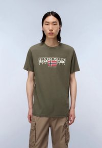 Bawełniany t-shirt w oliwkowej zieleni z okrągłym dekoltem, z grafiką w kolorze kremowym i czerwonym, zawierającą tekst oraz detale z flagą Norwegii.