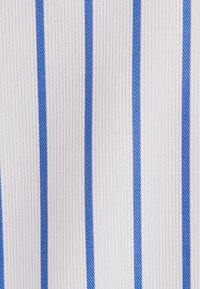 Witte stof met verticale, getextureerde blauwe strepen die gelijkmatig over het oppervlak zijn verdeeld.