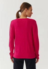 Fuchsia Strickpullover mit langen Ärmeln, Rundhalsausschnitt und gerippten Bündchen, mit glatter Textur und lässiger Passform. Rückansicht dargestellt.