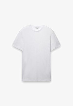 T-shirt bianca a maniche corte in morbido cotone, con scollo rotondo, taglio dritto e cuciture piatte senza loghi o motivi visibili.