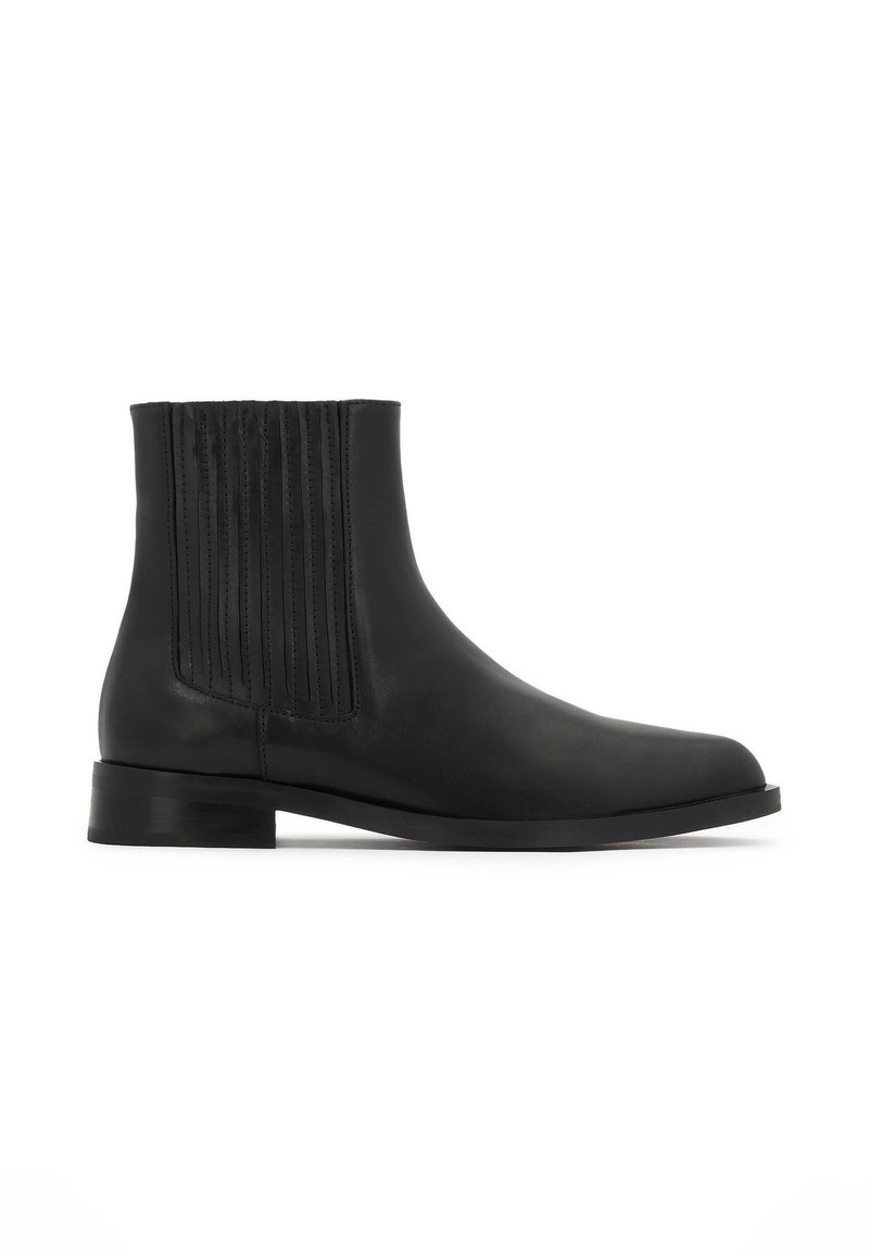 Stivaletto in pelle nera con cuciture verticali sui lati, silhouette snella, punta arrotondata e tacco basso impilato.
