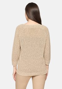 Pull en maille beige avec un motif texturé, manches 3/4 et large encolure. Coupe décontractée avec des finitions côtelées à l'ourlet.