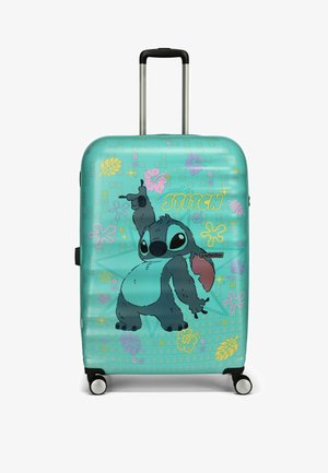Valise rigide turquoise arborant un personnage de dessin animé, avec un motif en grille, des accents floraux colorés, une poignée rétractable et des roues.
