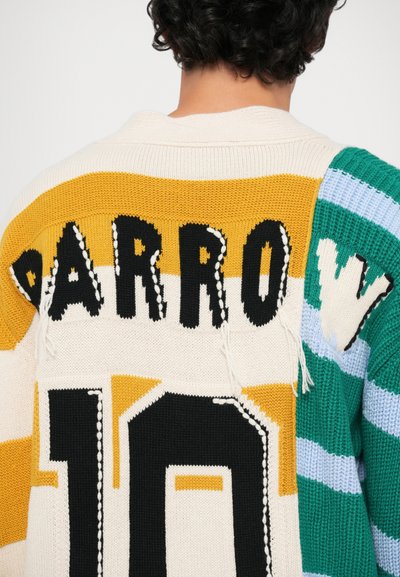 Pull en tricot avec des bandes jaunes, crème et vertes audacieuses, portant le nom "PARROW" et le numéro "10" en noir avec des bords effilochés.