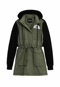 Olivengrüne Jacke mit schwarzen Ärmeln, Kordelzug in der Taille, doppelten Taschen und einer Kapuze. Besitzt ein weißes Grafikdesign auf der Brust.
