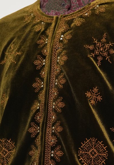 Sötétzöld bársonyos ruházat, bonyolult narancssárga hímzéssel és flitterekkel az elején, kerek nyakkivágással és diszkrét fényességgel.