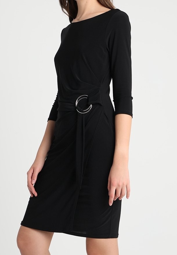 Černé šaty s tříčtvrtečními rukávy, zdobené zkrouceným předním dílem a stříbrným kruhovým detailem v pase. Měkká, elastická látka.