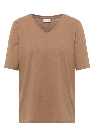 Femme aux cheveux courts bruns portant un t-shirt marron uni à manches courtes et un jean denim bleu clair, dos à la caméra.