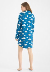 Modrá noční košile s vzorem oblaků a slunce, dlouhými rukávy, límečkem a volným střihem, který sahá těsně nad kolena.