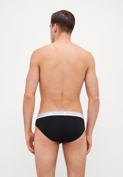 Culotte noire avec une ceinture blanche présentant la marque "DSQUARED2". Tissu lisse, design ajusté et style minimaliste.