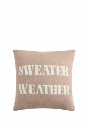 Quadratisches beiges Strickkissen mit weißem Text, der "SWEATER WEATHER" in Großbuchstaben sagt.