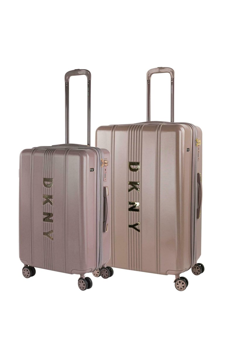 Dos maletas rígidas de DKNY en un color rosa dorado claro, con textura acanalada, acabado brillante y ruedas negras, exhiben un logotipo prominente.