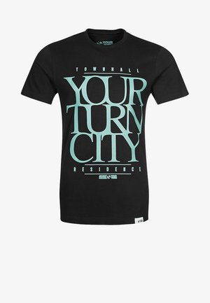 Schwarzes Baumwoll-T-Shirt mit großem türkisfarbenem Text "YOUR TURN CITY RESIDENCE" und einem Etikett am Saum. Kurze Ärmel, Rundhalsausschnitt.