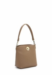 Tan leather handbag with a structured shape, adjustable strap, gold-tone hardware, and a zip closure featuring a circular logo detail.