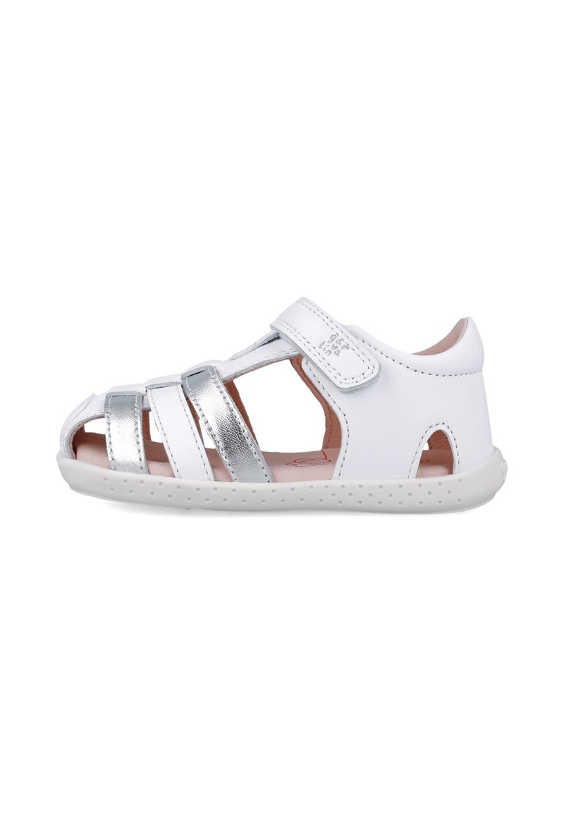 Sandalia blanca para niños hecha de cuero, con correas plateadas metálicas, cierre de velcro y suela de goma texturizada con orificios de ventilación.
