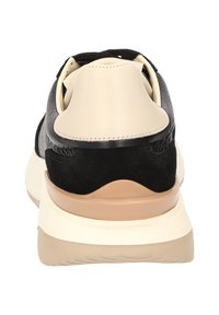 Schwarze und cremefarbene Sneaker aus strukturiertem Leder und Wildleder, mit einer klobigen beige-farbenen Sohle. Die Rückansicht zeigt eine gepolsterte Ferse und ein minimalistisches Design.