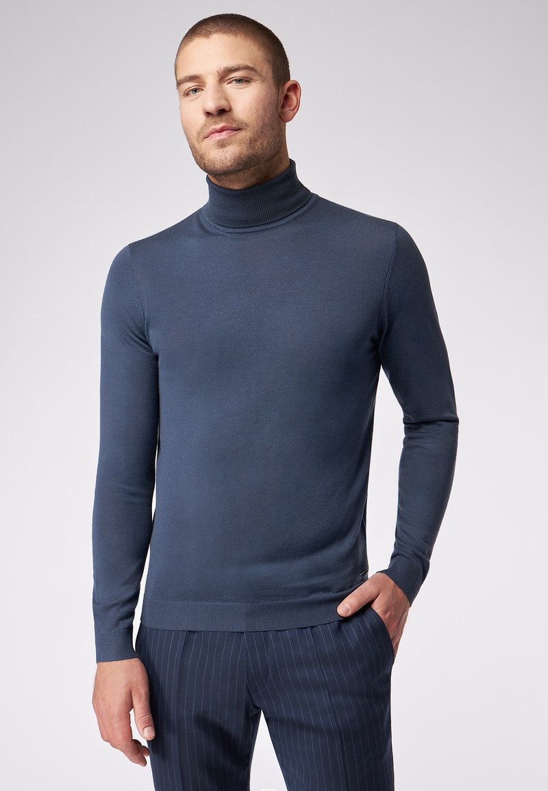 Dunkelblauer Rollkragenpullover in einer taillierten Passform, gefertigt aus geripptem Strickstoff. Mit langen Ärmeln und einem schlichten, unifarbenen Design ohne Muster.
