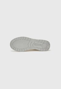 Kremfargede sneakers med en teksturert gummisåle, som har et heksagonalt mønster, forsterket tå og sidebranding.