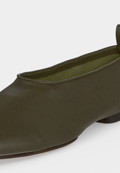 Chaussure plate vert olive avec bout arrondi, dessus en cuir lisse, petit talon et languette à l'arrière.