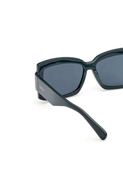 Svarta rektangulära solglasögon med tonade linser, glänsande plastbåge och släta, raka gavlar. Anmärkningsvärt logotypdetalj på templet.