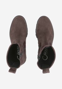 Bottines en suède marron avec une semelle en caoutchouc, des zips latéraux et une languette. L'intérieur est doté d'une doublure noire avec des détails de marque.