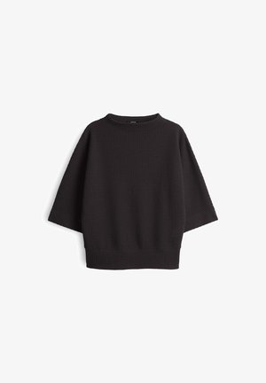 Waffle-textured, loose-fitting black sweater with a round neckline and wide sleeves, featuring a ribbed hem and cuffs.
