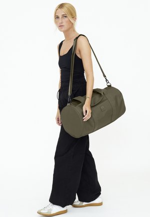 Duffel bag van olijfgroen stof, cilindrische vorm, dubbele handvatten, verstelbare schouderband, stevige stiksels, eenvoudig ontwerp zonder patronen.