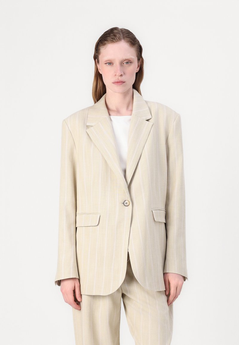 Beige pinstripe blazer met een enkele knoopsluiting, brede revers, twee voorkruisen en een ontspannen pasvorm. Gemaakt van lichtgewicht stof.