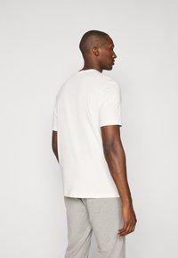 Weißes T-Shirt mit kurzen Ärmeln und rundem Ausschnitt, aus glattem Stoff gefertigt, mit einem lässigen Schnitt und minimalen Nähdetails.