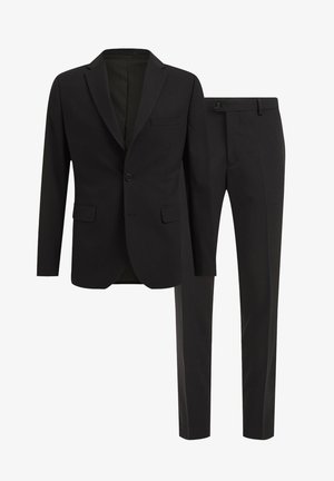 Crni odijelo koje se sastoji od uskog sakoa s reverima i odgovarajućih krojenih hlača. Glatka tkanina s minimalističkim dizajnom i bez vidljivih uzoraka.