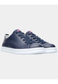 Tenisi din piele navy cu talpă din cauciuc albă, vârf rotund și design cu șireturi. Prezintă perforații pe vârf și branding pe limbă.